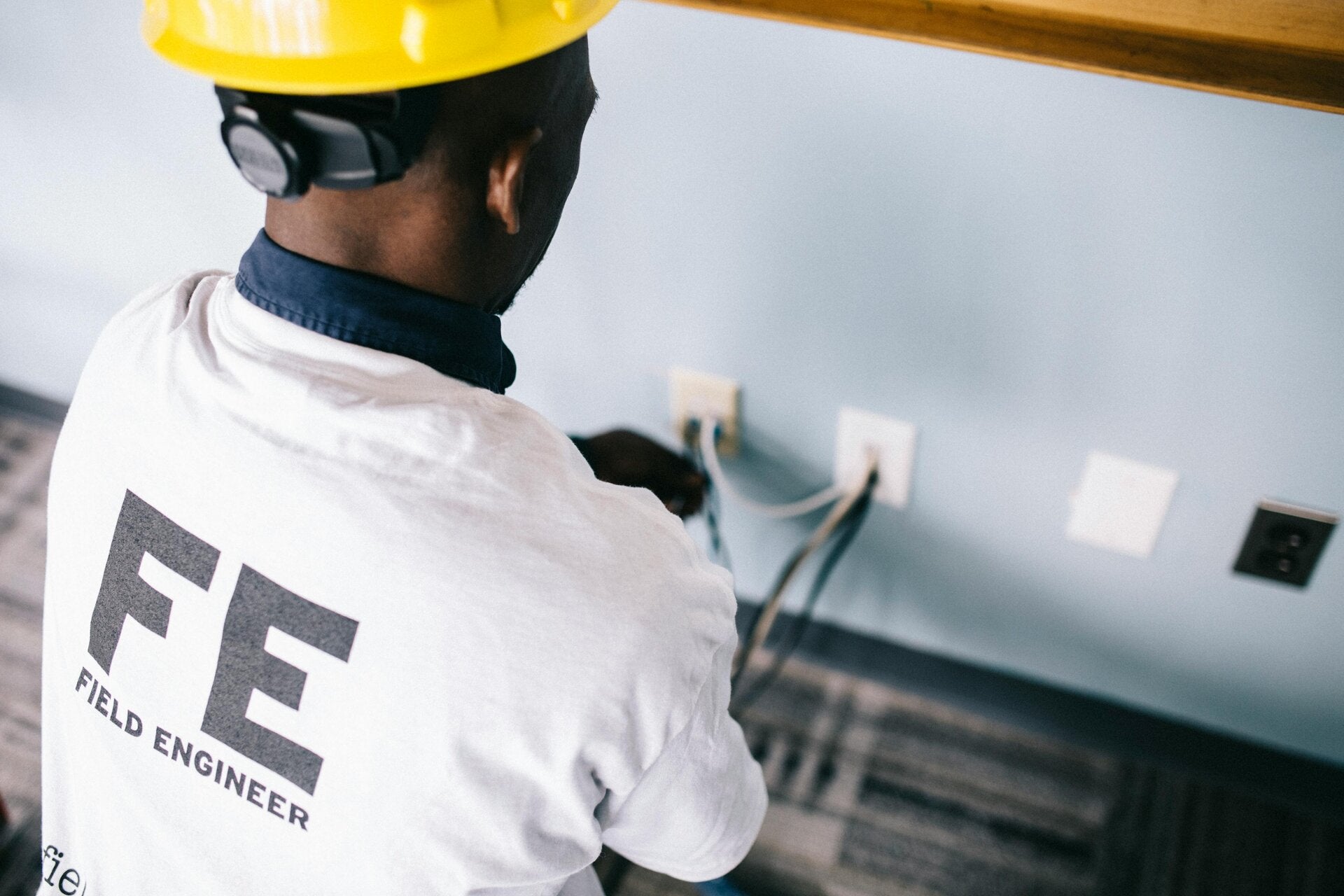 Close-up of an electrician's hands working on wall-mounted electrical connections in Doncaster